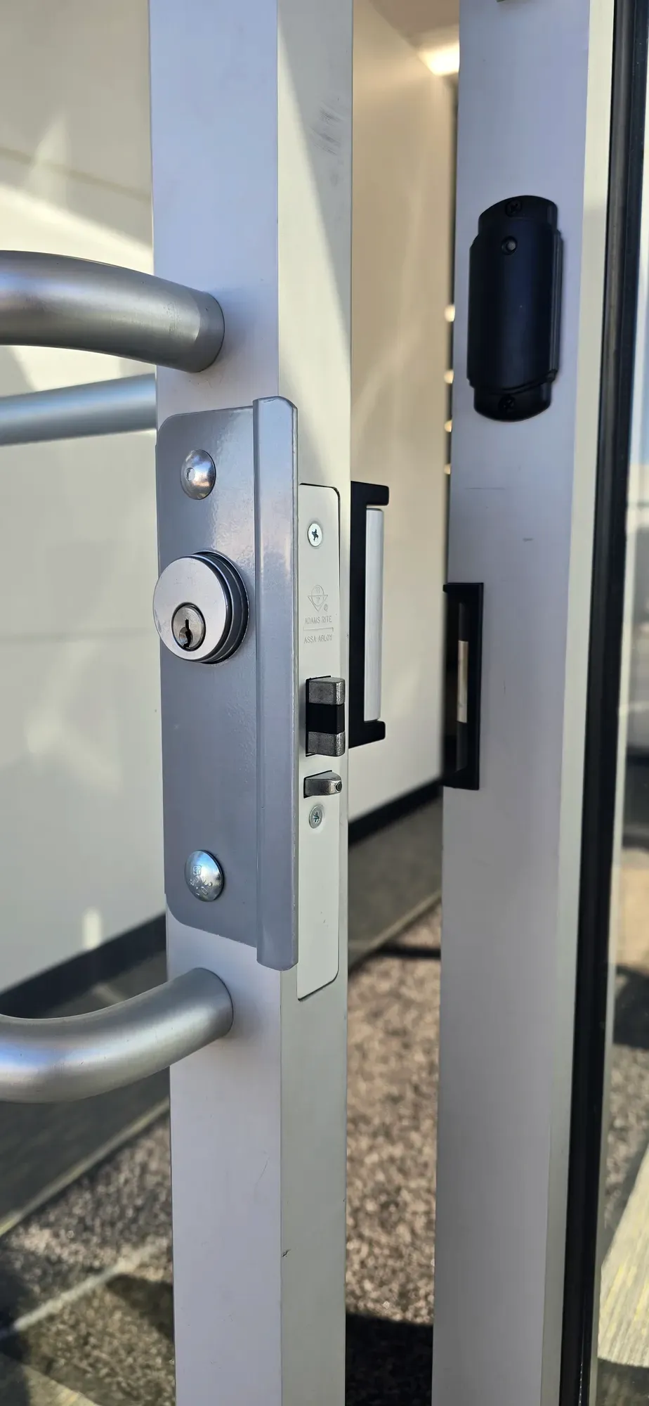 Adams Rite mortise lock and electric strike on an aluminum storefront door