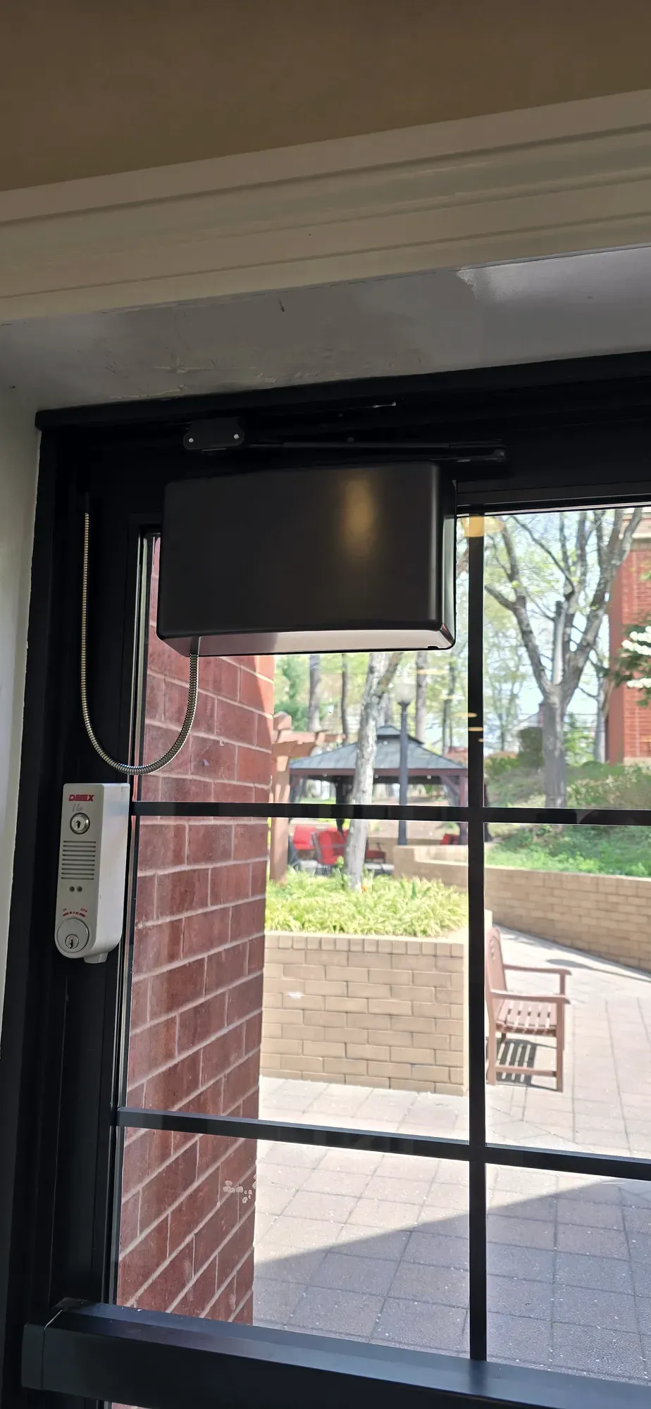 LCN compact automatic door operator and Detex exit alarm on a glass entry door
