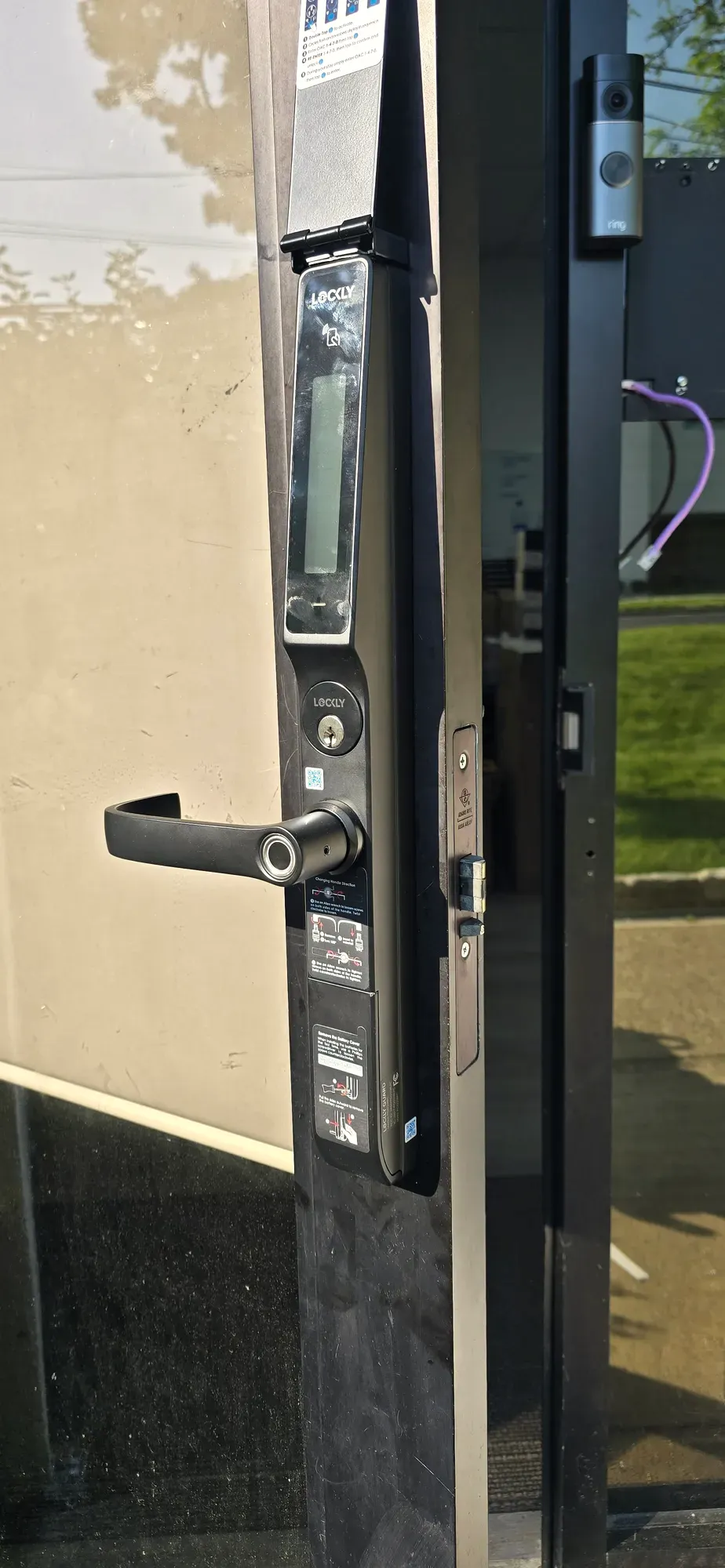 Smart mortise lever lock with fingerprint reader on a dark aluminum storefront door
