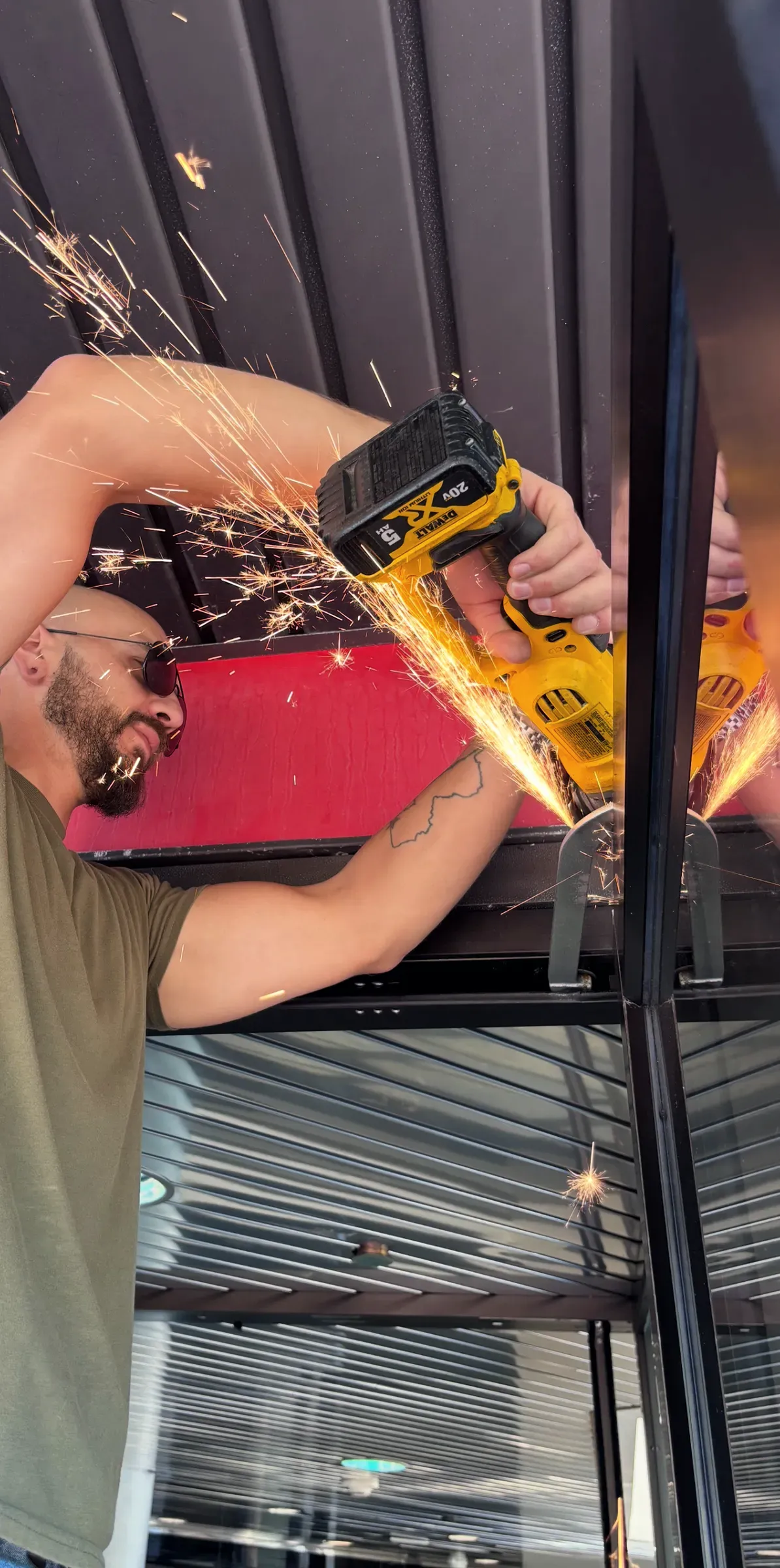 Christopher cutting steel on a commercial storefront door frame