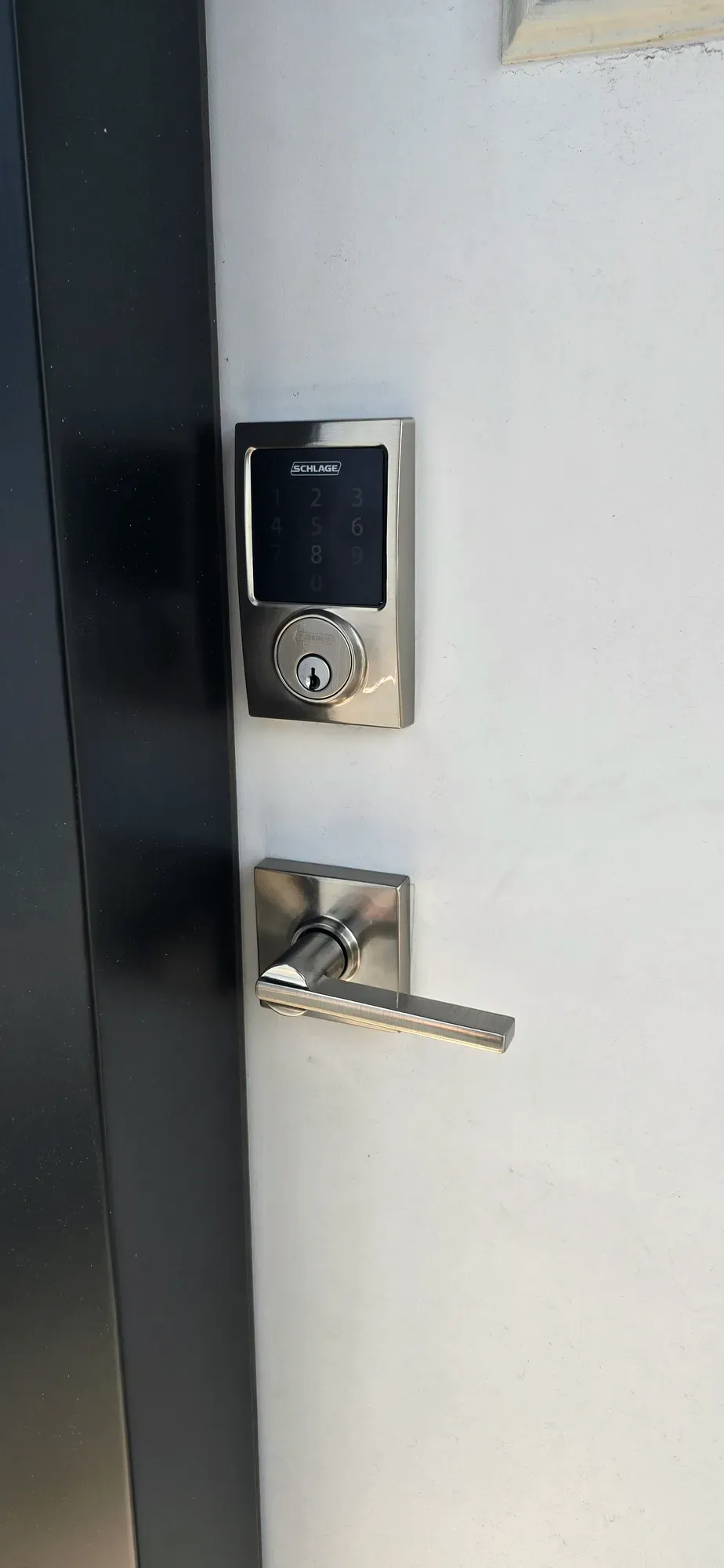 Satin nickel keypad deadbolt and lever installed on an entry door